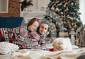 Beautiful couple together with the dog of chow-chow in Christmas decorations