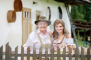 Beautiful couple in traditional bavarian dress against rural house