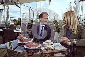 Beautiful couple of travelers enjoying breakfast on a hotel veranda