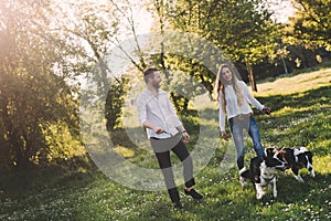Beautiful couple walking dogs and bonding in nature