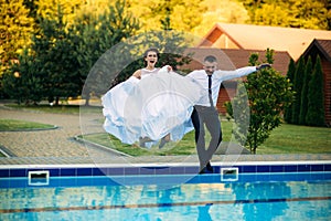 Beautiful couple walking in the park in their wedding day.