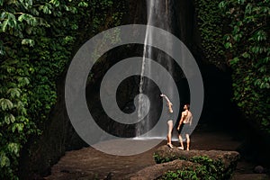 Beautiful couple at the waterfall. A couple in love travels to Indonesia on the island of Bali. A man and a woman at a waterfall