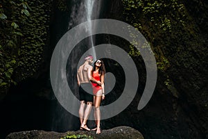 Beautiful couple at a waterfall in Indonesia. Honeymoon trip. Happy couple on the island of Bali.