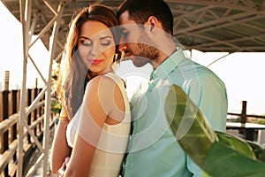 Beautiful couple wearing elegant clothes embracing in outdoor restaurant