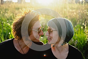 Beautiful couple of  young man and young woman flirt outdoor  in  park  during golden hour