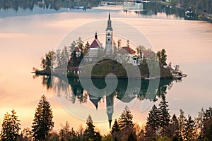 Beautiful cozy Lake Bled and the church on the island in the background with castle in the morning lights in the Julian Alps