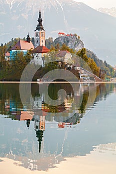 Beautiful cozy Lake Bled and the church on the island in the background with castle in the morning lights in the Julian Alps