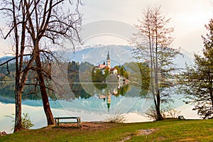 Beautiful cozy Lake Bled and the church on the island in the background with castle in the morning lights in the Julian Alps