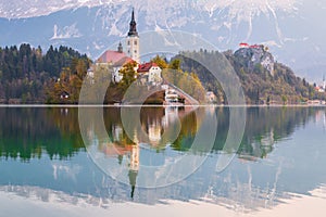 Beautiful cozy Lake Bled and the church on the island in the background with castle in the morning lights in the Julian Alps