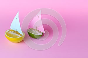 Beautiful creative decoration background idea with fresh fruit lime and lemon yacht, sailboat with sail on pink  background