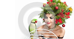 Beautiful creative Xmas makeup and hair style indoor shot. Beauty Fashion Model Girl with green parrot