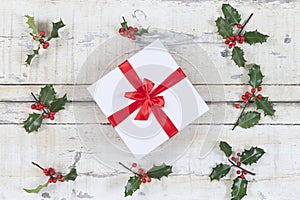 Beautiful Cristmas gifts i the middle of Holly on old white painted cracked wooden background