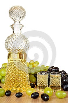 Beautiful crystal bottle and two glasses of traditional bulgarian home made strong alcohol grape drink grozdova rakia on a photo