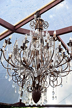Beautiful crystal chandelier luminaria with lights, hanging from the glass ceiling
