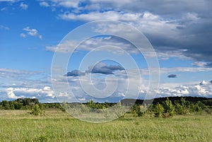 Beautiful cumulus clouds over meadows and fields in the valley