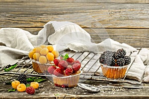 beautiful cupcakes with berries on wooden background