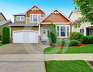 Beautiful curb appeal of American house in olive exterior paint.