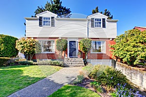 Beautiful curb appeal of two level house with brick and white siding.