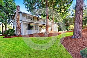 Beautiful curb appeal of two story house with large trees in front.