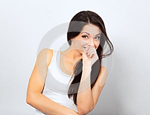 Beautiful curious smiling woman holding the head the hands thinking and looking up in casual white t-shirt and long hair on blue