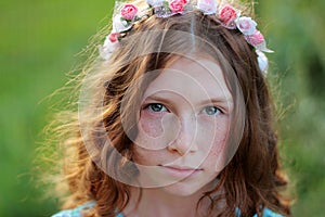 Beautiful curl girl in a wreath of flowers