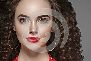 Beautiful curle hair female in red with red lips and dress manicure, beauty red afro hairstyle