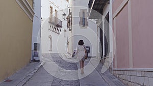 Beautiful curly brunette tourist in the Mediterranean village of Sitges on the bakground