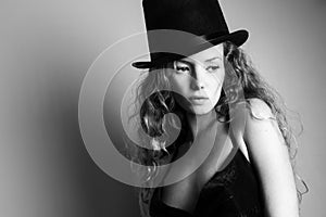 Beautiful curly girl in a black hat