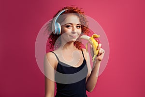 Beautiful curly girl eating a banana