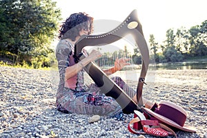 Beautiful curly hair woman playing the harp