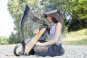 Beautiful curly hair woman playing the harp