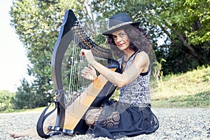 Beautiful curly hair woman playing the harp