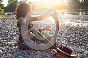 Beautiful curly hair woman playing the harp