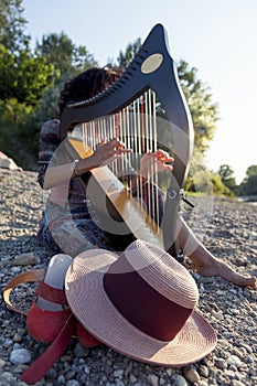 Beautiful curly hair woman playing the harp