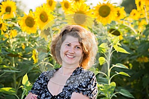 Beautiful curly-haired woman in field of sunflowers