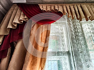 Beautiful curtain on the window and transparent tulle curtain. Abstract background, texture, pattern. Space for text and