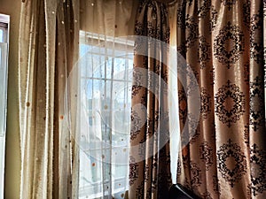 Beautiful curtain on the window and transparent tulle curtain. Abstract background, texture, pattern. Space for text and