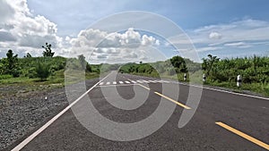 A beautiful curved road with hills on the side and blue sky in the background