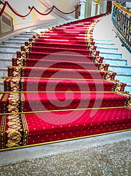 Beautiful curved staircase with red carpet for guests