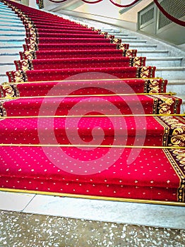 Beautiful curved staircase with red carpet for guests