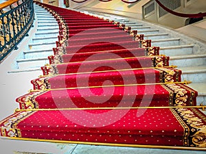 Beautiful curved staircase with red carpet for guests