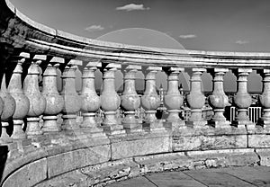 Beautiful curving stone balustrade detail with cityscape seen between the posts.