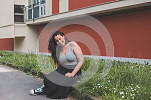 Beautiful curvy girl sitting in the grass