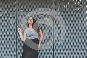 Beautiful curvy girl smoking a cigarette in an urban context