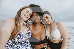 Beautiful curvy women taking a selfie at the beach