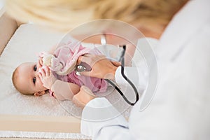 Beautiful cute baby girl with doctor with stethoscope