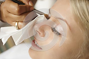 Beautiful, cute blond bride doing makeup before wedding day. Lon