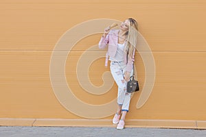 Beautiful cute funny amazing young hipster teen girl eating ice cream cone bright casual wear, orange background, urban
