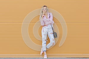 Beautiful cute funny amazing young hipster teen girl eating ice cream cone, laughs happy, bright casual wear, orange