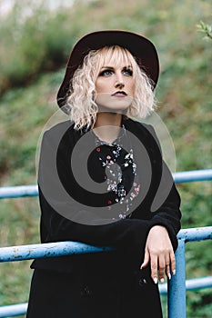 Beautiful cute girl in red hat and black coat walking in the city